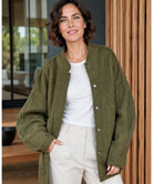 Frau kombiniert Oversized Bouclé Bomberjacke mit Hose in Ivory