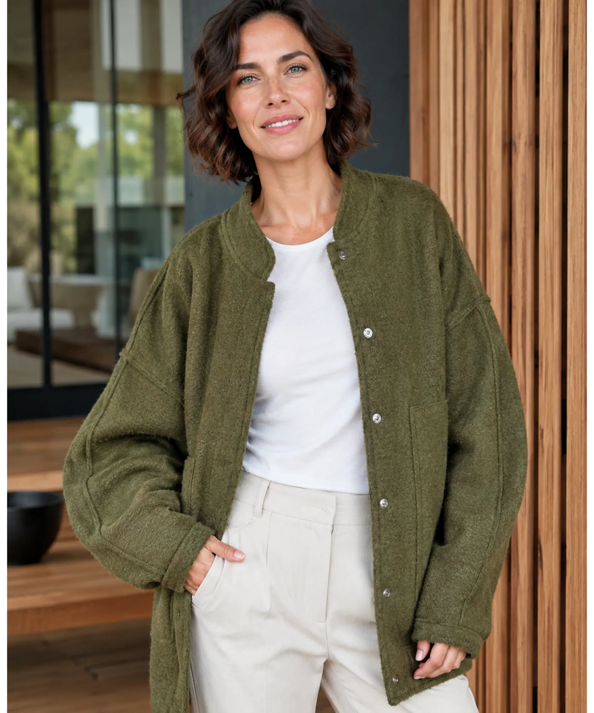 Frau kombiniert Oversized Bouclé Bomberjacke mit Hose in Ivory