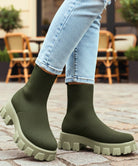 Damen Sockenstiefel in Weiß auf städtischem Untergrund, griffige Sohle sichtbar
